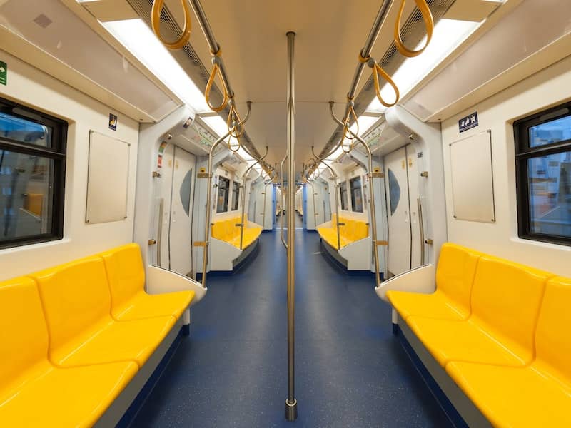 Interior view of city train with yellow rows of seats